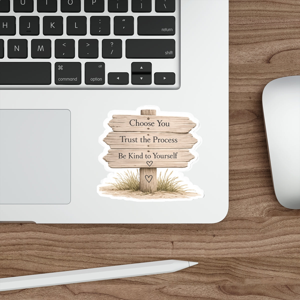Wooden beach sign quote sticker shown beside the trackpad on a silver laptop